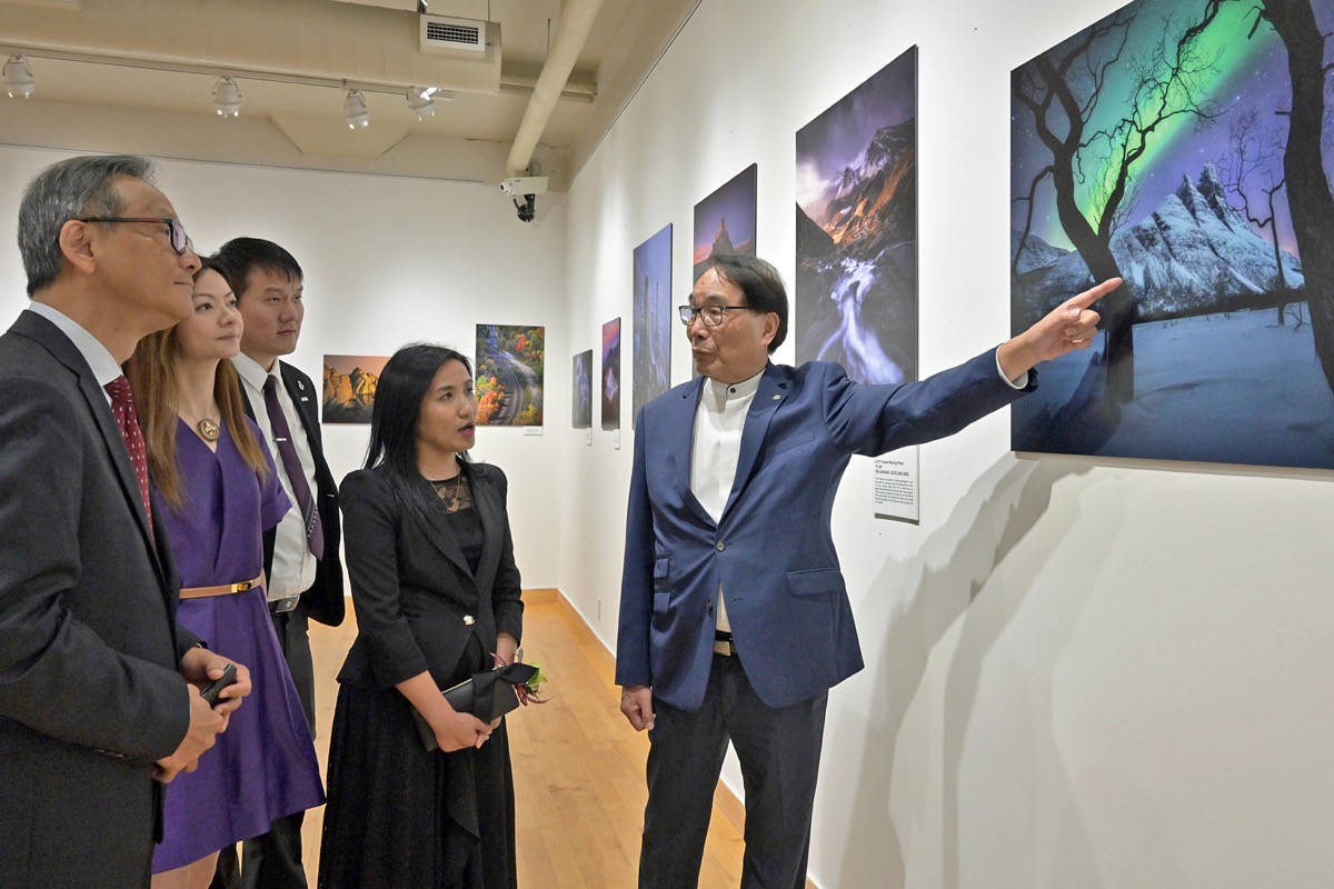 Ms Mo (second right) tours the photography exhibition entitled “A Landscape Journey” at the Dr Hin-Shiu Hung Art Gallery of the Chinese Cultural Centre of Greater Toronto, and listens to the introduction by Chairman of the Chinese Canadian Photographic Society of Toronto, Mr Stephen Siu (right), with other guests of Imperial Ball at the gallery.
