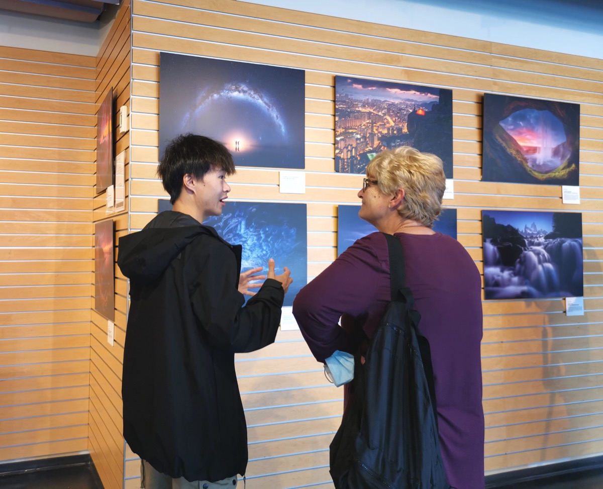 香港攝影師袁斯樂（左）於九月六日在溫哥華卑詩大學Robson Square舉行的「大地之旅」攝影展的「與攝影師交流」活動上與一位攝影師交流。